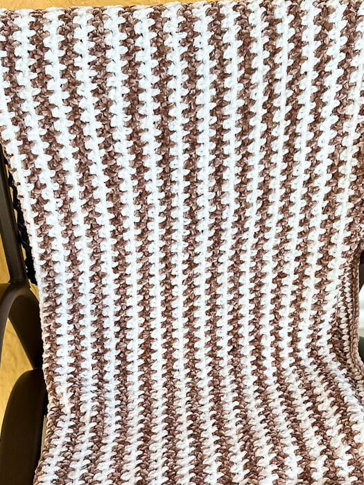 Brown and cream velvet baby blanket on a chair